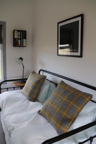 米德尔顿Kirkapol Beach Apartment的一张带两个枕头的床和墙上的电视