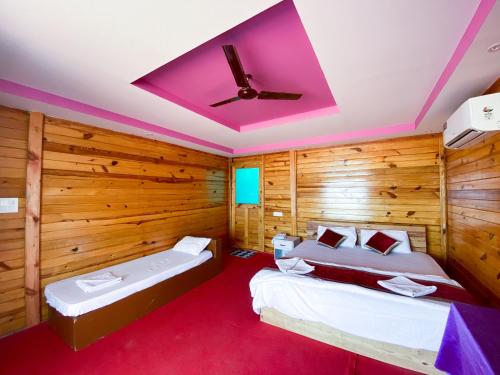 阿贡达Om Sai Beach Huts的配有木墙和天花板的客房内的两张床