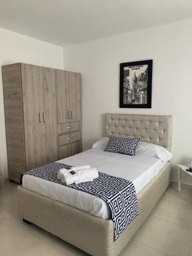 卡塔赫纳Mar de Indias House的一间卧室配有一张床和一个木制橱柜