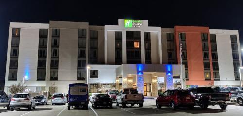 欧文达拉斯沃思堡机场南快捷假日套房酒店的晚上在酒店前面的一个停车场