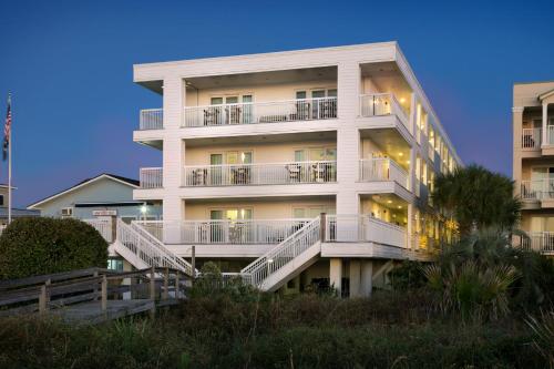 棕榈岛海滨酒店 - 棕榈岛的前面有楼梯的高大的白色建筑