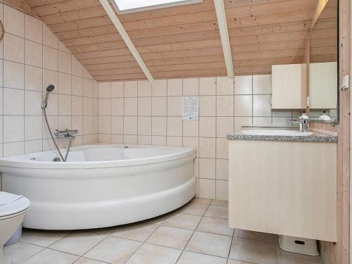 博托比Four-Bedroom Holiday home in Væggerløse 8的带浴缸、卫生间和盥洗盆的浴室