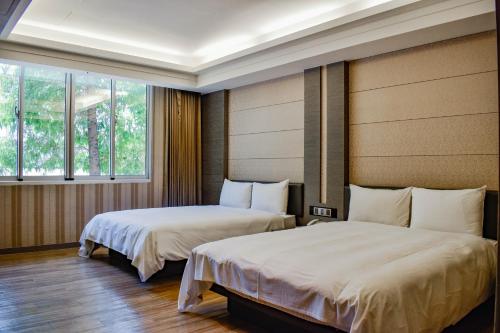 台南塔木德酒店Classic 台南台南馆的带2扇窗户的客房内的2张床