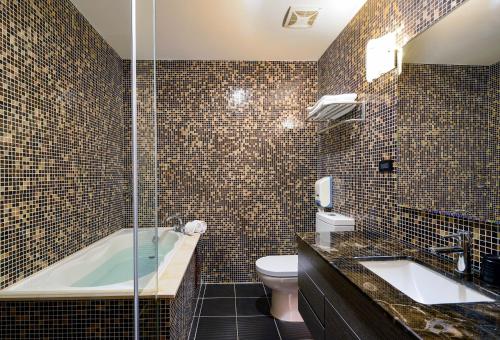 台南塔木德酒店Classic 台南台南馆的带浴缸、卫生间和盥洗盆的浴室