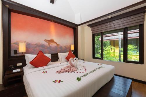 卡伦海滩The Village Resort & Spa - SHA Plus的一间卧室配有一张大床和一张大画