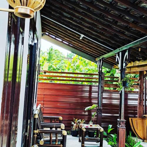 日惹Omah Kampong的一个带两把椅子和红色门的庭院