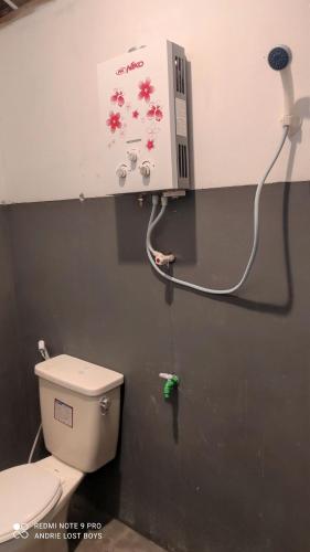 日惹Omah Kampong的一间带卫生间的浴室和墙上的一台机器