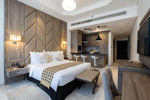迪拜TIME Onyx Hotel Apartments的一间带大床的卧室和一间厨房