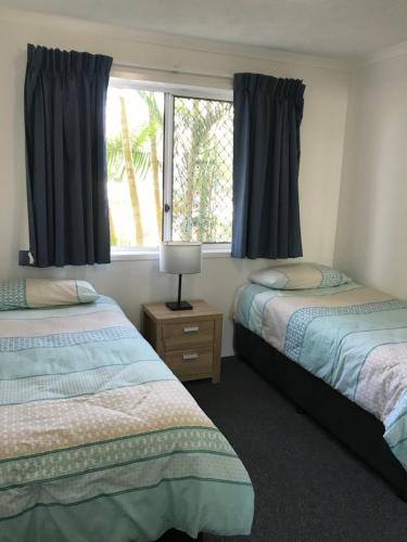 黄金海岸海雾棕榈酒店的一间卧室设有两张床和窗户。