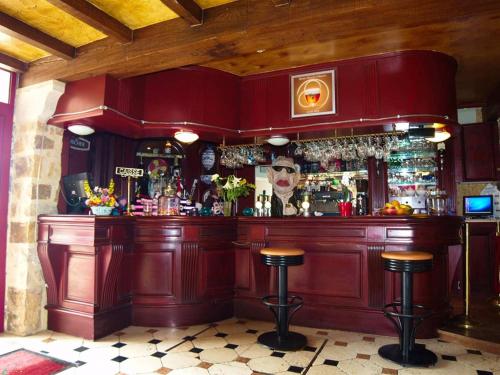 普勒比扬Les Chambres du Sillon的酒吧,酒吧里设有红色的吧台和凳子