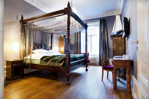 斯德哥尔摩赫尔斯坦酒店的一间卧室配有一张天蓬床和一张书桌