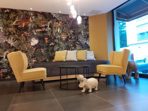 巴黎阿尔贝特王子里昂贝西酒店的客厅配有沙发、两把椅子和一只狗