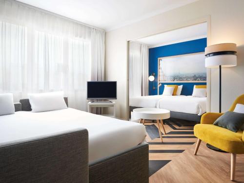 巴黎凡尔赛宫阿德吉奥公寓酒店的酒店客房,配有两张床和椅子
