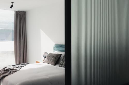但尼丁Ebb-Dunedin的一间卧室设有一张床和一个窗口