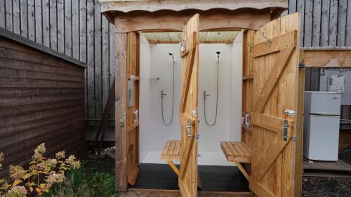 霍伊克Shepherd's Hut Westcote的木质浴室,设有4个淋浴间,位于大楼内
