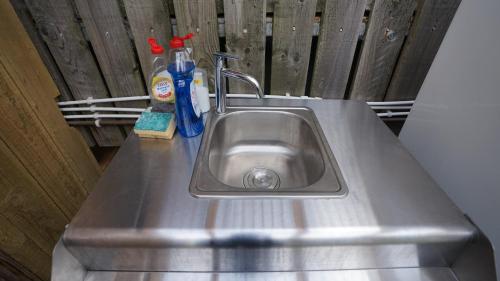 霍伊克Shepherd's Hut Westcote的不锈钢厨房水槽,带清洁产品