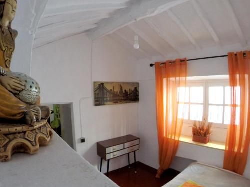 阿尔戈多纳莱斯2 bedrooms house with enclosed garden and wifi at Algodonales的一间卧室设有橙色窗帘的窗户