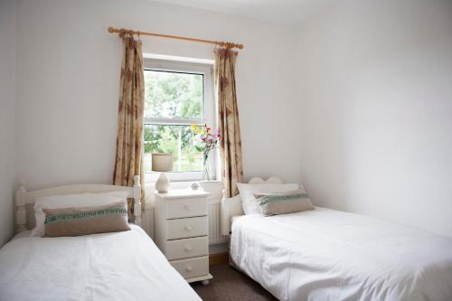 GrangeInviting 4-Bed House in Strokestown的卧室设有两张床,带窗户