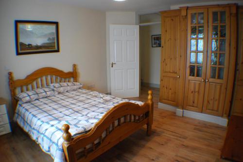 恩尼斯克朗Cosy 2-Bed Cottage in Sligo的一间卧室配有木质床和木地板