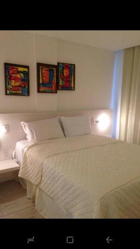 马塞约WATER FRONT的卧室配有一张白色床,墙上挂有三张照片