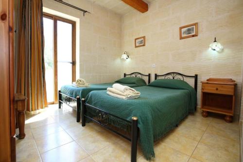 沙拉Ta Danjela 4 bedroom Villa with private pool的一间卧室设有一张绿色的床和一个窗户。