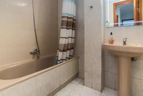 阿尔卡拉德荷那利斯Apartamentos Complutum的浴室配有盥洗盆、浴缸和盥洗盆