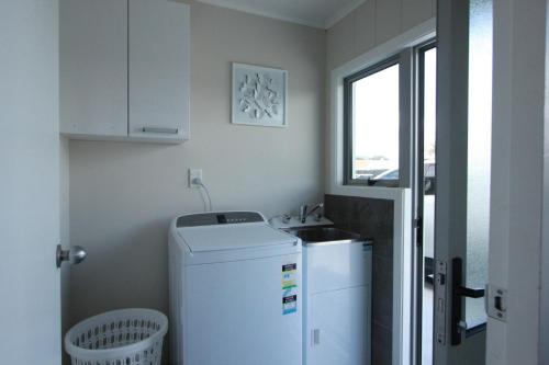 罗托鲁瓦Rose Apartments Central Rotorua- Accommodation & Private Spa的一间带水槽和冰箱的小厨房