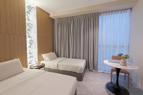 哥打京那巴鲁Harper Boutique Hotel at Sutera Avenue的酒店客房设有两张床和窗户。