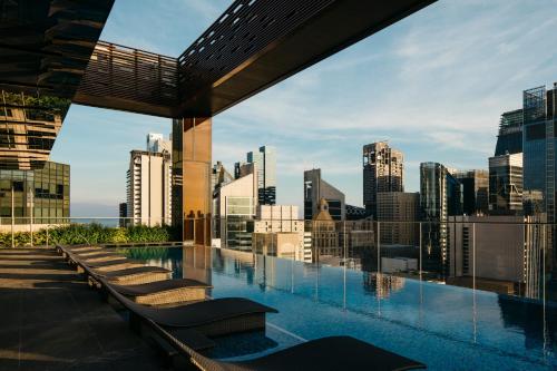 新加坡The Clan Hotel Singapore by Far East Hospitality的一座城市天际线建筑屋顶上的游泳池