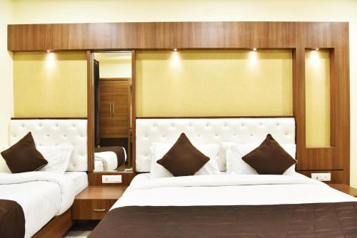 阿姆利则Hotel Amritsar International的一间卧室设有两张床和大镜子