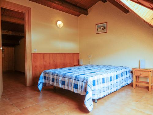 帕斯底拉卡萨Kione Paradís Blanc的一间卧室配有一张带蓝白色毯子的床