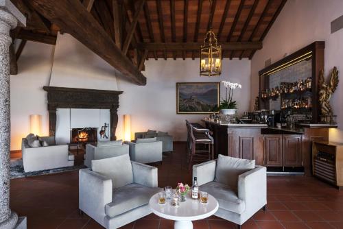 洛迦诺Villa Orselina - Small Luxury Hotel的带壁炉的客厅和酒吧