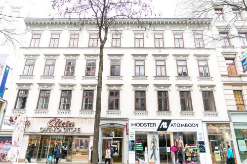 维也纳Mariahilfer Boutique Rooms - Virtual Reception & Self-Checkin的一条拥有商店的城市街道上的白色大建筑