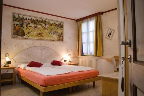 佩利扎诺阿格里图尔邦滕佩利旅馆的卧室配有一张床,墙上挂有绘画作品