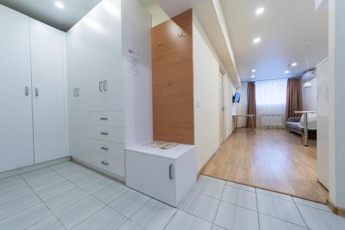 基辅FlatRent SmartHouse的一间设有白色橱柜的房间和一间带桌子的房间