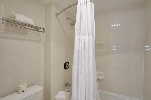 波茨坦克拉克森宾馆的一间带白色淋浴帘的浴室