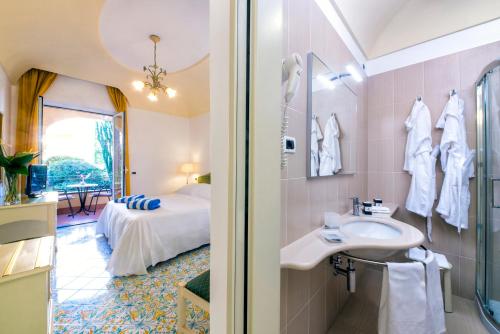 伊斯基亚Hotel San Lorenzo Thermal Spa的一间带水槽的浴室和一张位于客房内的床