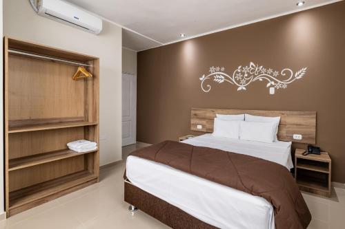皮乌拉Hotel Solec Piura的卧室配有一张大床,墙上挂有吊灯