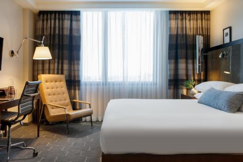 亚特兰大Kimpton Overland Hotel - Atlanta Airport, an IHG Hotel的一间卧室配有一张床、一张桌子和一把椅子