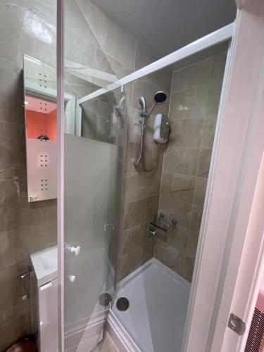 哈罗Modern Garden House的带淋浴的浴室和玻璃门
