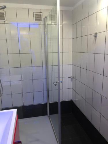 波兹南Tanie Pokoje Blisko Lotniska的浴室里设有玻璃门淋浴