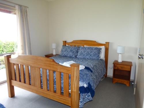 KarapiroKauri Lodge Karapiro的一间卧室设有一张木床和一个窗户。