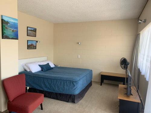 派西亚阿拉莫纳汽车旅馆 的一间卧室配有一张床和一张红色椅子