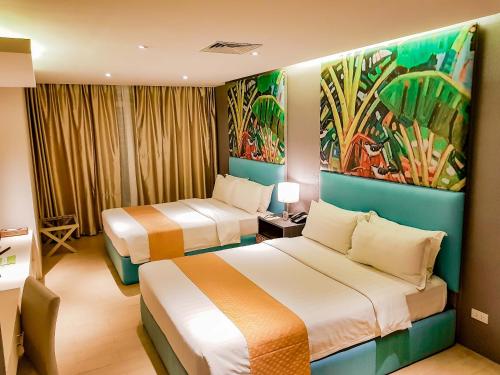 公主港阿齐扎天堂酒店 的酒店客房设有两张床,墙上挂有绘画作品