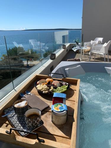 曼德雷Villa Natura luxury apartments的游泳池旁桌子上的一盘食物