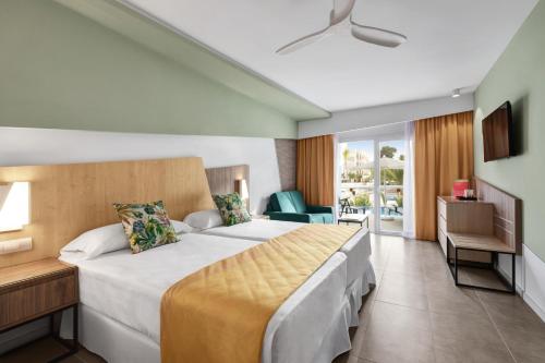 帕尔马海滩Hotel Riu Playa Park - 0'0 All Inclusive的酒店客房设有一张大床和一个阳台。