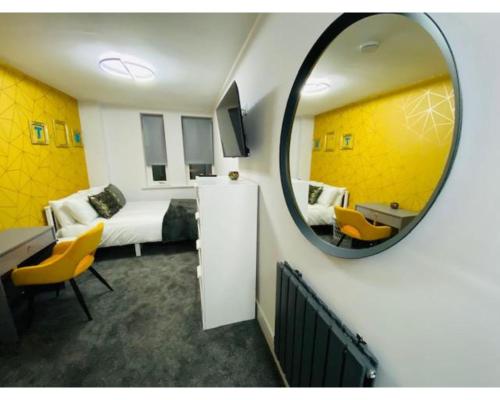 EtruriaTownhouse PLUS @ Lower Beth Street Stoke的客房设有镜子、一张床和一张书桌