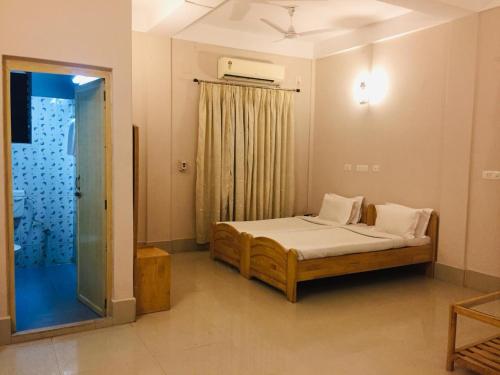 MelāgharLake Side Resort Neermahal的一间卧室设有一张床和一个玻璃门