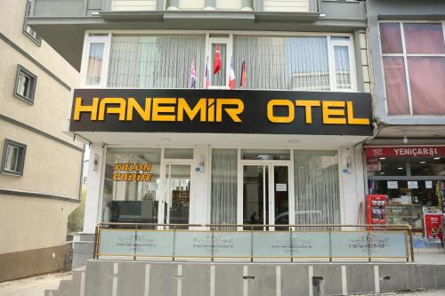 TatvanHanemir Otel的建筑物上一个印有字迹的标志的前方的商店