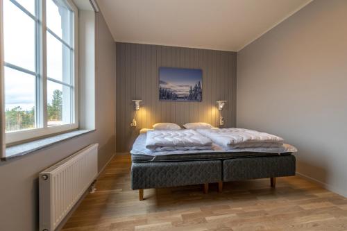 TranstrandHotell Kurbits的卧室配有床,位于带2个窗户的房间